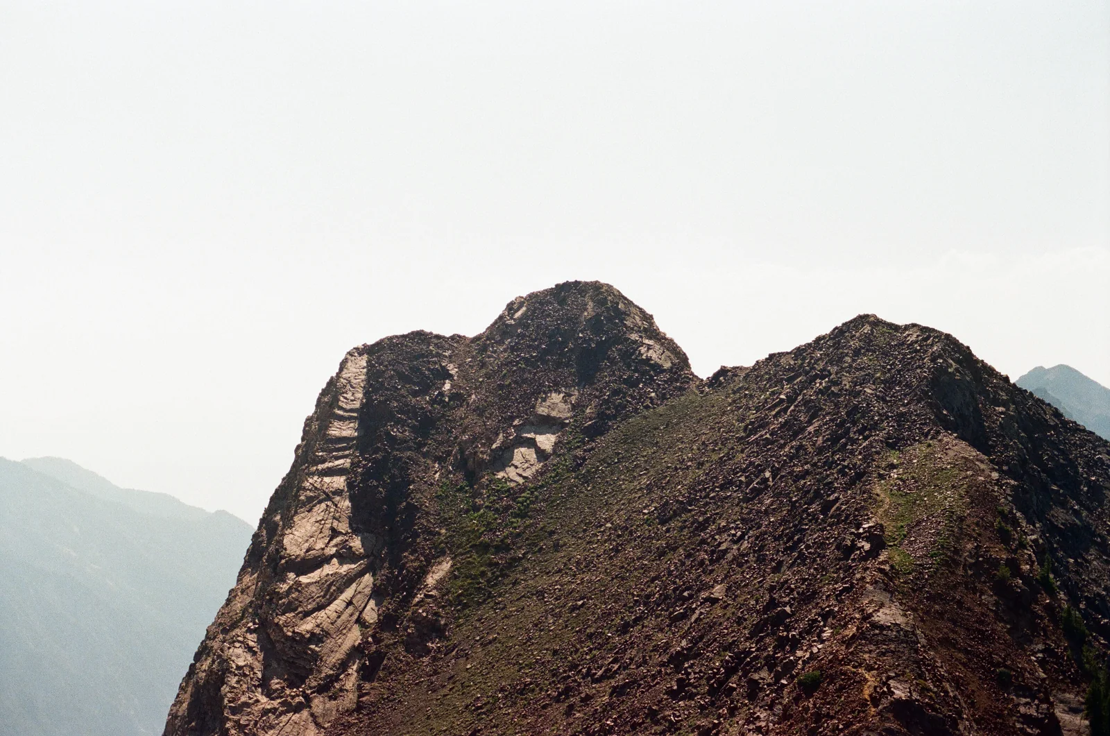 A steep mountain ridge rising into an open sky.